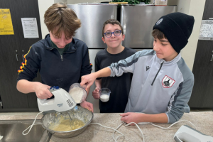  three students cooking together 
